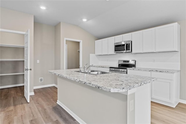 37839 W 207th Ter, Edgerton, KS 66021 - kitchen featuring stainless steel appliances, white cabinetry, light wood-style floors, an island with sink, and lofted ceiling