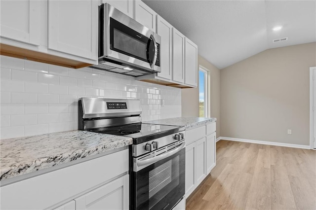 37839 W 207th Ter, Edgerton, KS 66021 - kitchen featuring stainless steel appliances, vaulted ceiling, light wood-type flooring, tasteful backsplash, and white cabinets