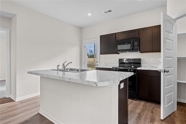 37854 W 207th Ter, Edgerton, KS 66021 - kitchen with black appliances, a center island with sink, light wood-type flooring, light countertops, and dark brown cabinets