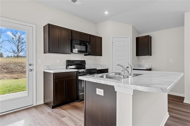 37854 W 207th Ter, Edgerton, KS 66021 - kitchen featuring black appliances, light wood-style floors, dark brown cabinets, an island with sink, and light countertops