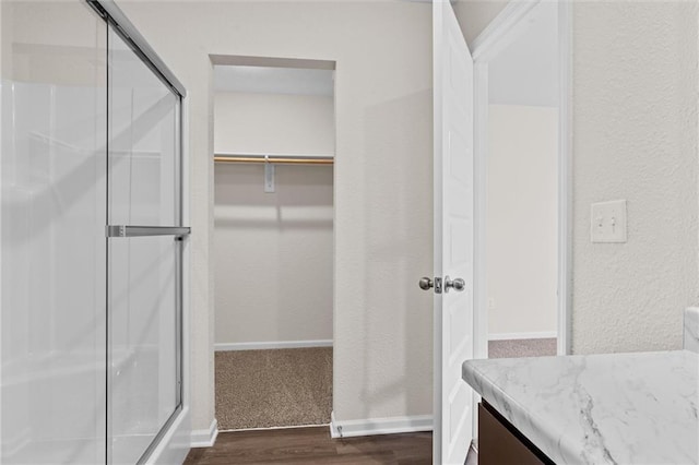 37854 W 207th Ter, Edgerton, KS 66021 - bathroom featuring wood finished floors, a stall shower, vanity, and a spacious closet