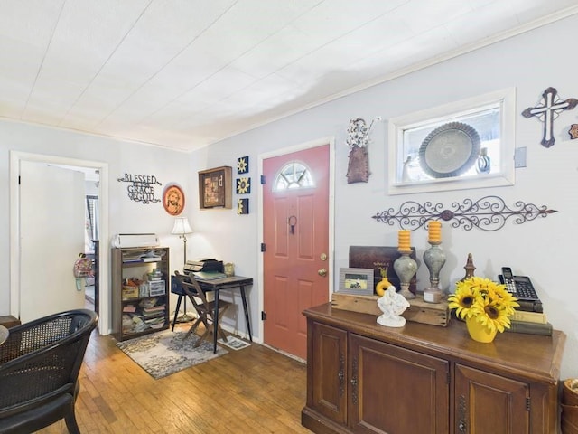 foyer entrance featuring light wood-style floors and ornamental molding