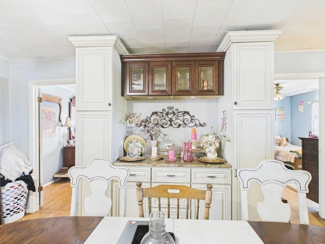 dining space with light wood-style floors and ornamental molding