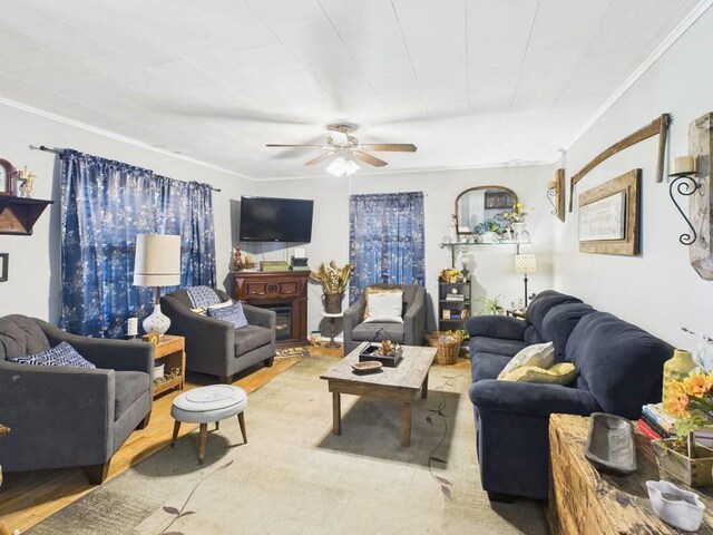 living area featuring ceiling fan, ornamental molding, and wood finished floors