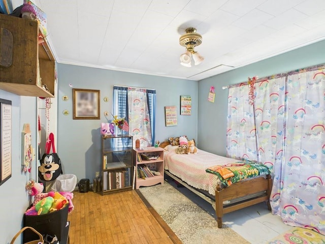 bedroom with light wood-type flooring and crown molding