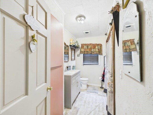 full bath featuring vanity, ornamental molding, and toilet