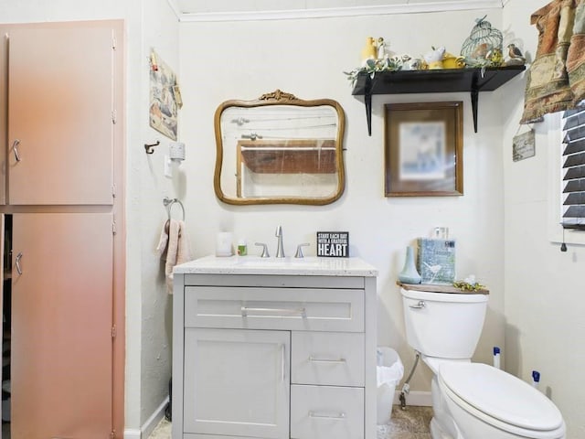 bathroom featuring baseboards, vanity, and toilet