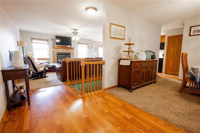 11295 County Road 366, Savannah, MO 64485 - living area with a tiled fireplace, a ceiling fan, baseboards, and wood finished floors