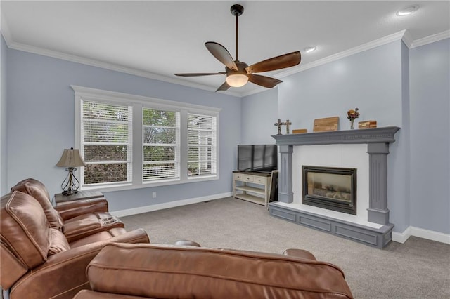 living room with a glass covered fireplace, crown molding, carpet, and a ceiling fan