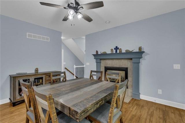 dining space featuring baseboards, visible vents, ceiling fan, and light wood finished floors