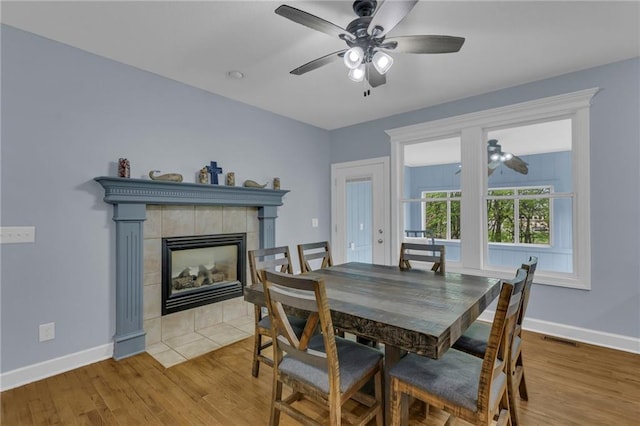dining space with a ceiling fan, baseboards, visible vents, and wood finished floors