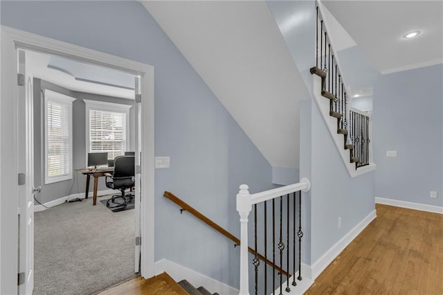 staircase featuring baseboards, vaulted ceiling, recessed lighting, and wood finished floors