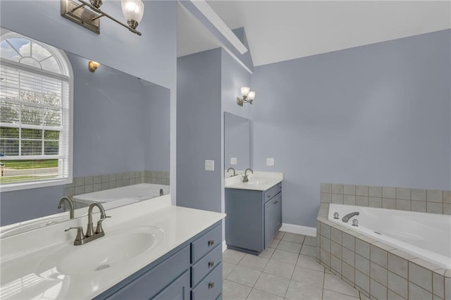 bathroom with a sink, tile patterned floors, a garden tub, and two vanities