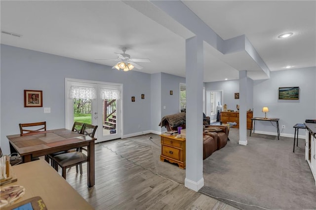 interior space with visible vents, a ceiling fan, baseboards, and a wealth of natural light