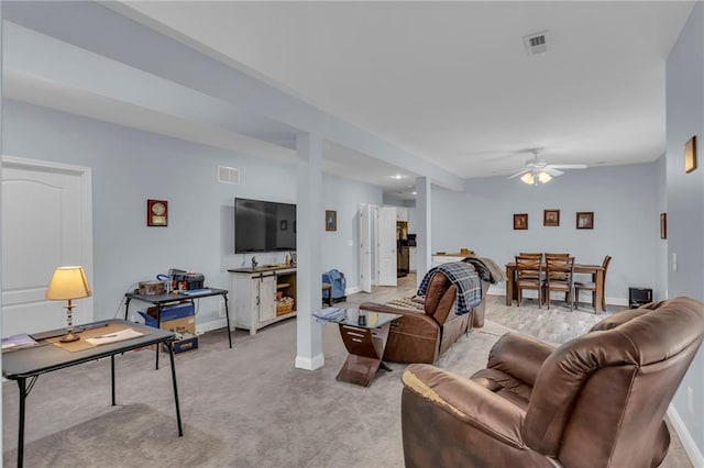 living room featuring baseboards, light carpet, a ceiling fan, and visible vents