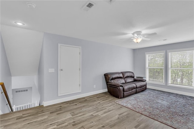 living area featuring baseboards, a ceiling fan, wood finished floors, and visible vents