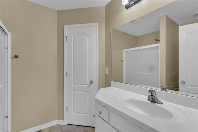 full bathroom with vanity, baseboards, and walk in shower