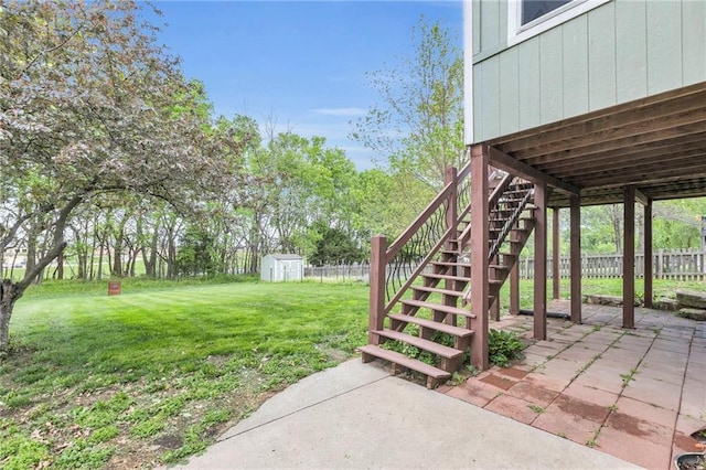 view of yard featuring a storage shed, fence, a patio, and an outbuilding