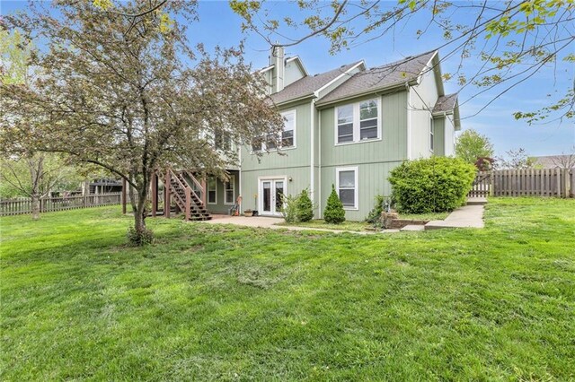 back of house with french doors, stairway, a fenced backyard, a yard, and a patio