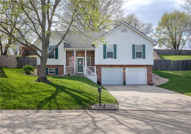 raised ranch with brick siding, a garage, driveway, and a front yard