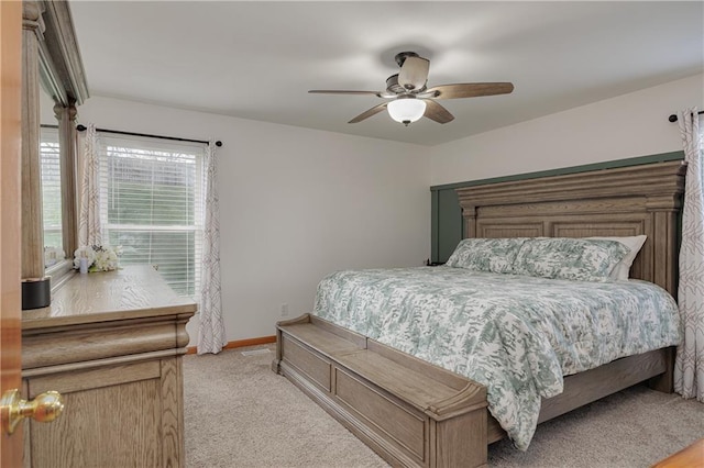 bedroom with baseboards, a ceiling fan, and light colored carpet