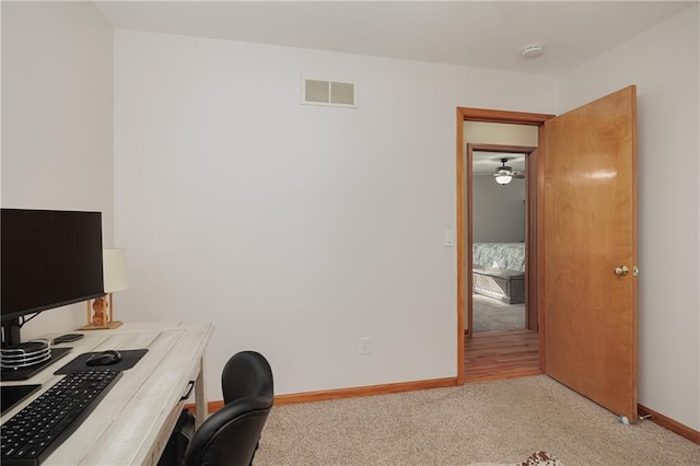 carpeted office space with baseboards, visible vents, and ceiling fan