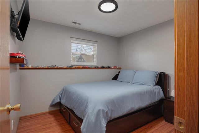 bedroom featuring wood finished floors and visible vents