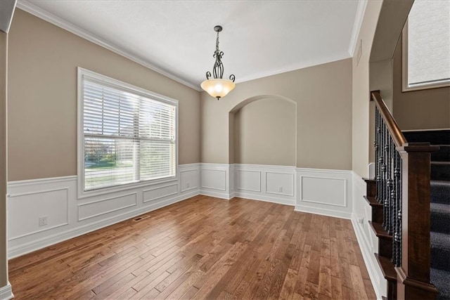 11194 S Hastings St, Olathe, KS 66061 - unfurnished dining area with stairway, a wainscoted wall, ornamental molding, and hardwood / wood-style floors