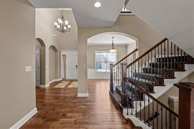 11194 S Hastings St, Olathe, KS 66061 - foyer entrance with an inviting chandelier, arched walkways, stairs, and hardwood / wood-style floors