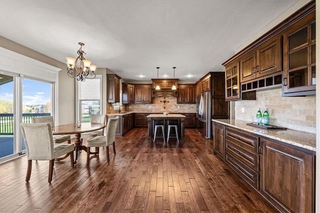 11194 S Hastings St, Olathe, KS 66061 - kitchen featuring freestanding refrigerator, dark wood-style flooring, a notable chandelier, and a kitchen island
