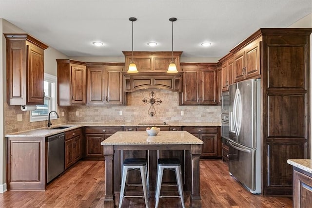 11194 S Hastings St, Olathe, KS 66061 - kitchen with dark wood-style flooring, stainless steel appliances, a sink, and a kitchen bar