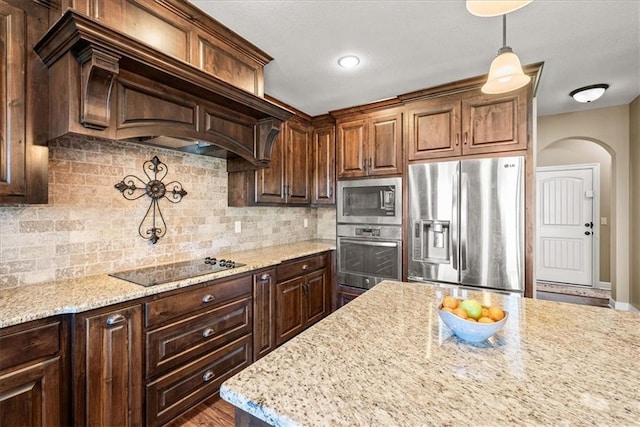 11194 S Hastings St, Olathe, KS 66061 - kitchen with decorative backsplash, custom exhaust hood, light stone counters, arched walkways, and appliances with stainless steel finishes
