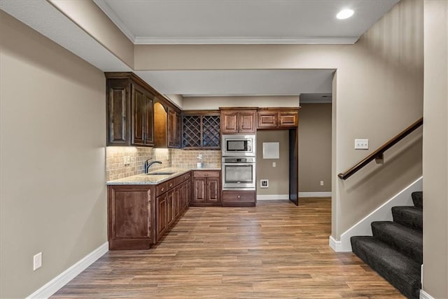 11194 S Hastings St, Olathe, KS 66061 - kitchen with light wood-style floors, baseboards, a sink, appliances with stainless steel finishes, and backsplash