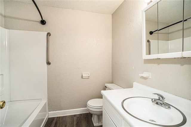 3552 S Lynn St, Independence, MO 64055 - full bathroom with shower / bath combination, toilet, a textured wall, baseboards, and wood finished floors