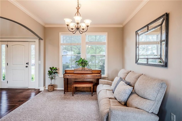 interior space with baseboards, ornamental molding, wood finished floors, and a chandelier