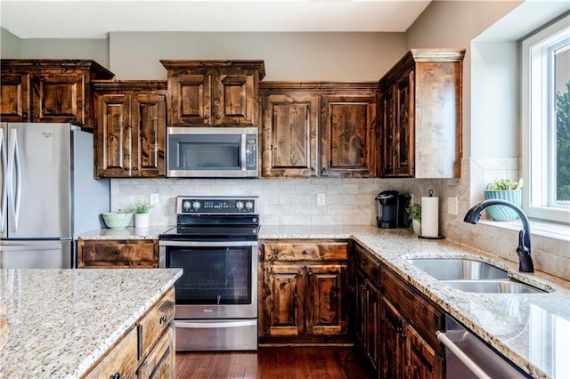 kitchen with plenty of natural light, a sink, dark wood-style floors, and stainless steel appliances