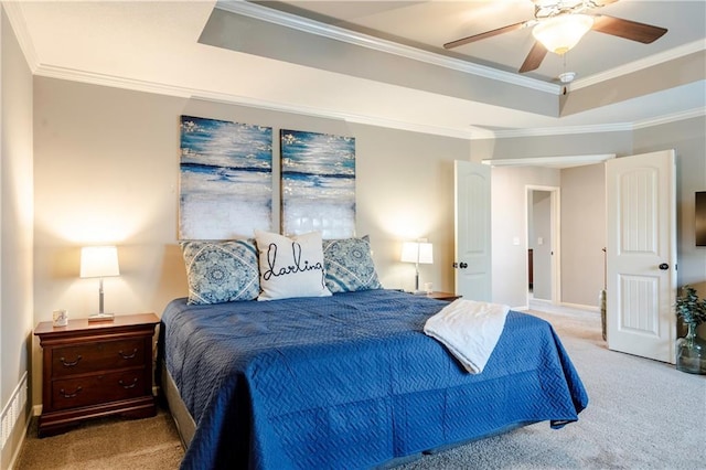 carpeted bedroom with crown molding, ceiling fan, and a raised ceiling