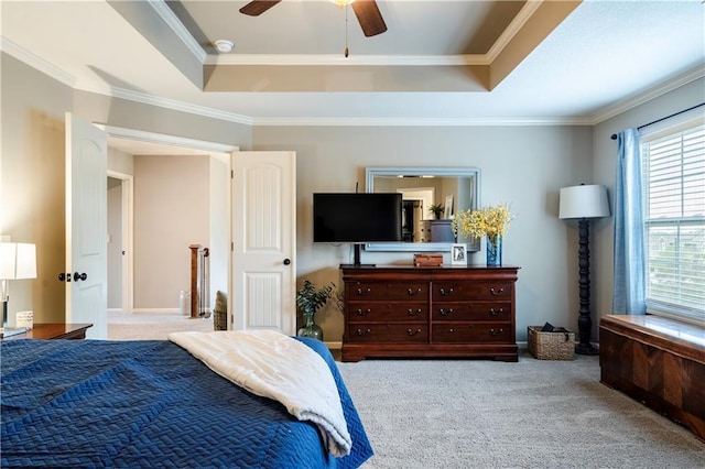 bedroom with carpet floors, ornamental molding, a ceiling fan, and a raised ceiling