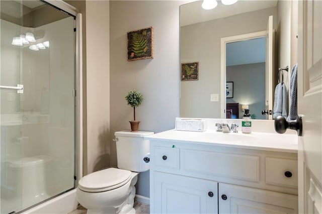 bathroom featuring vanity, a shower stall, and toilet