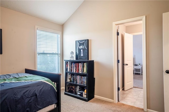 carpeted bedroom with baseboards and vaulted ceiling