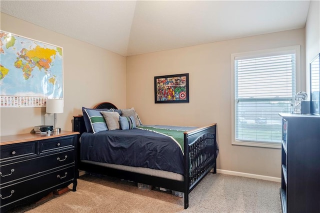bedroom with baseboards, vaulted ceiling, light carpet, and multiple windows