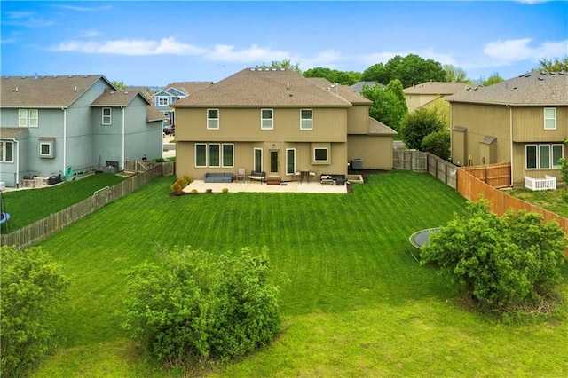 back of property with a residential view, a patio, a yard, and a fenced backyard