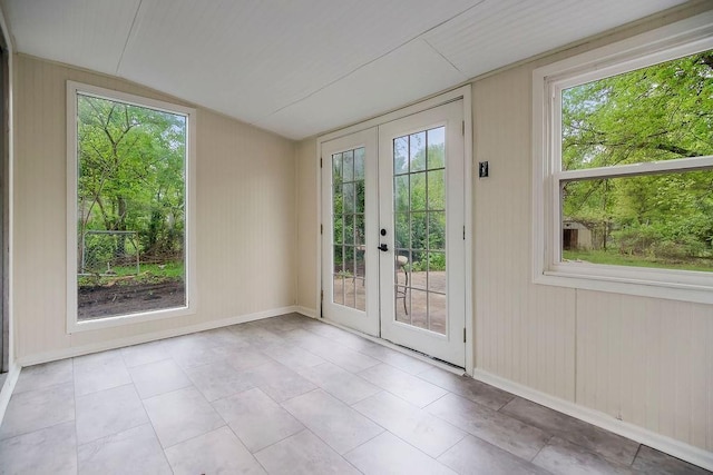 doorway to outside with french doors, baseboards, lofted ceiling, and a healthy amount of sunlight