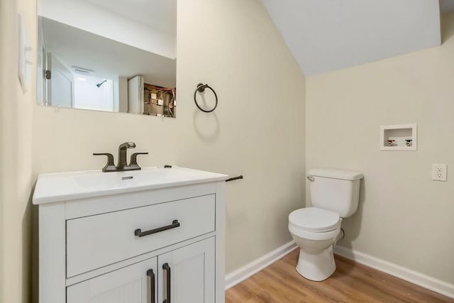 bathroom featuring baseboards, wood finished floors, toilet, and vanity