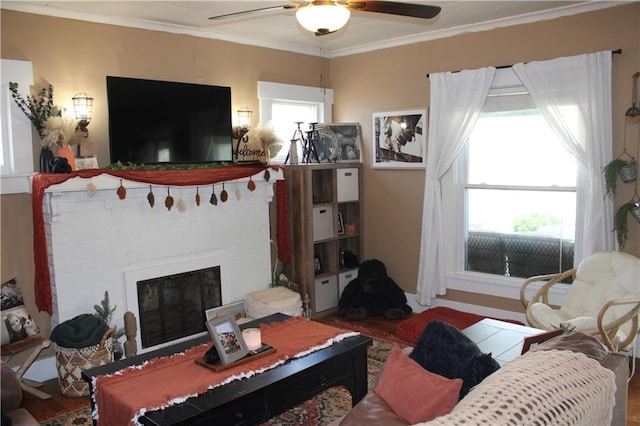 living area with ceiling fan, crown molding, and a brick fireplace