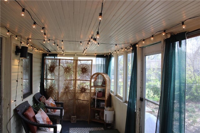 sunroom / solarium featuring rail lighting and wood ceiling