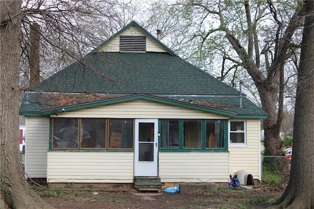 bungalow with a sunroom, a shingled roof, fence, and entry steps
