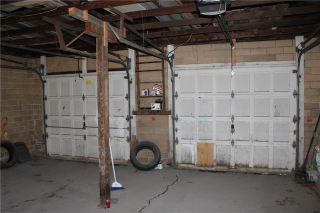 garage featuring a garage door opener and concrete block wall
