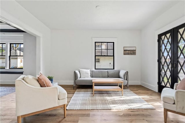 living room with plenty of natural light, baseboards, and wood finished floors