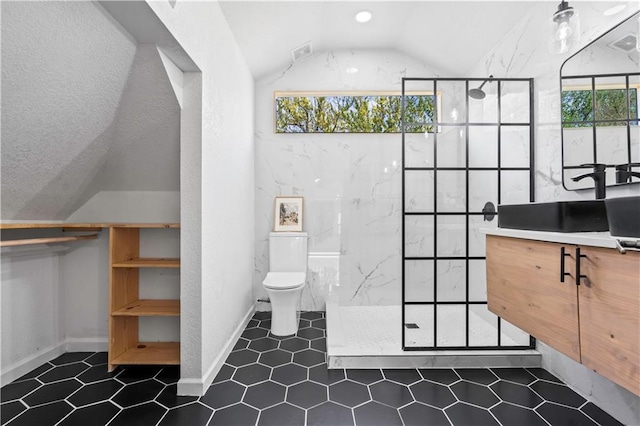bathroom featuring tile patterned flooring, vaulted ceiling, toilet, vanity, and a walk in shower